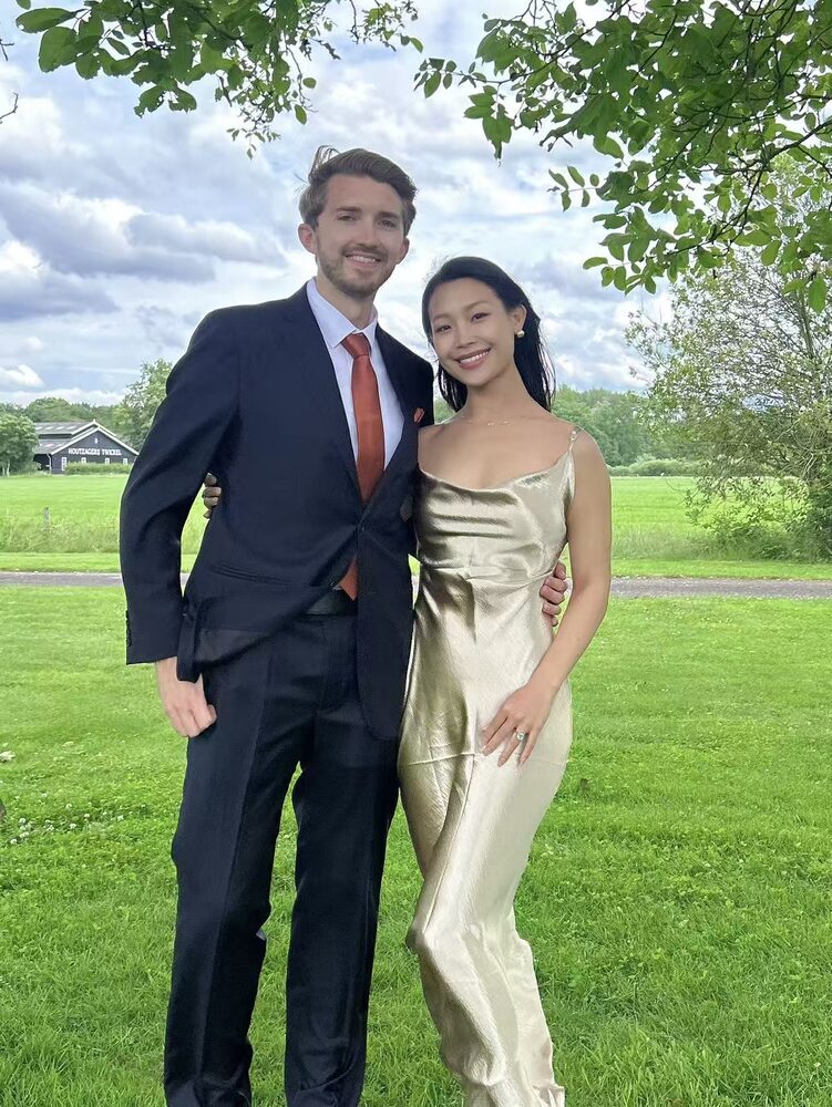 Lina in a satin dress and Michael in a suit on a lawn