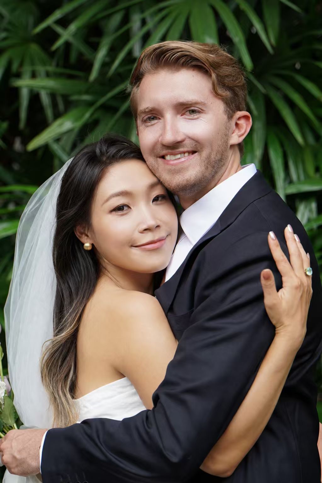 Michael and Lina in wedding attire — Lina in a white dress and veil, Michael in a navy suit
