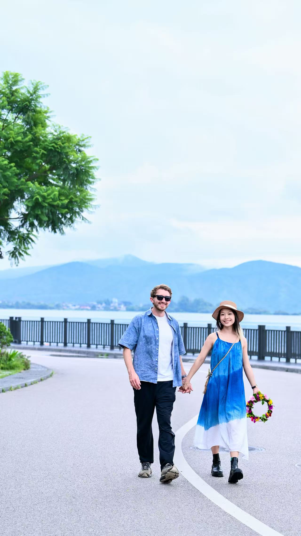 Michael and Lina walking hand in hand along the lakeside in Dali
