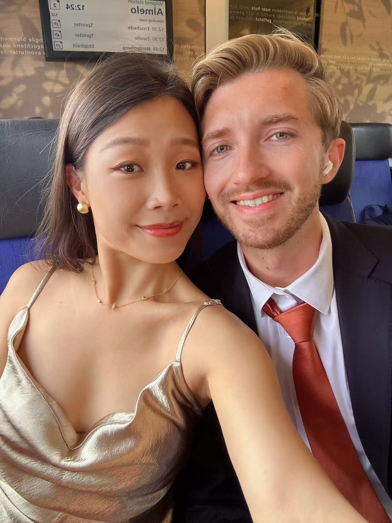 Michael and Lina on a train, dressed up and smiling