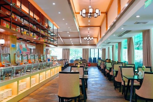 Bright, spacious on-site restaurant with buffet counters and dining tables by tall windows