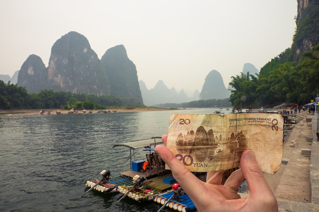 The ¥20 banknote held up against the matching karst scenery at Xingping
